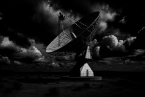 Satellite ground station site with large parabolic antenna in remote landscape